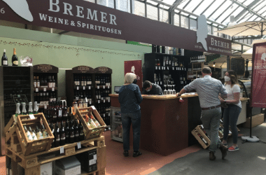 Verkaufsstand der Weinhandlung Bremer in der Markthalle Kassel mit Kunden